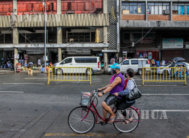 ဖိလစ်ပိုင်နိုင်ငံ မနီလာမြို့၌ နှာခေါင်းစည်း တပ်ဆင်၍ စက်ဘီးစီးနင်းသွားလာနေသူများအား တွေ့ရစဉ်(ဆင်ဟွာ)