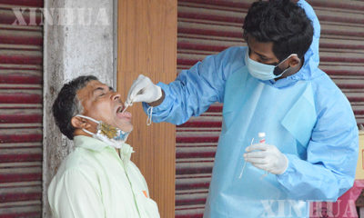 အိန္ဒိယနိုင်ငံ၌ ဆေးဘက်ဆိုင်ရာ ဝန်ထမ်း တစ်ဦးက ဈေးသည်တစ်ဦးအား COVID-19 ရောဂါ ရှိ/မရှိ စစ်ဆေးရန် ဓာတ်ခွဲနမူနာ ရယူနေစဉ်(ဆင်ဟွာ)