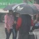 မိုးရေထဲတွင် ထီးဖြင့် သွားလာနေသူတစ်ချို့အားတွေ့ရစဉ် (ဆင်ဟွာ)