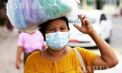ရန်ကုန်မြို့၌ နှာခေါင်းစည်း တပ်ဆင်သွားလာနေသူ အမျိုးသမီးတစ်ဦးအား တွေ့ရစဉ်(ဆင်ဟွာ)