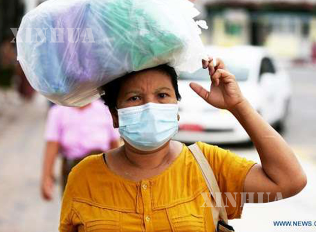 ရန်ကုန်မြို့ တွင် နှာခေါင်းစည်းဖြင့်သွားလာနေသူတစ်ဦးအားတွေ့ရစဉ် (ဆင်ဟွာ)