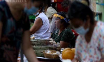 နှာခေါင်းစည်းဖြင့် ဈေးရောင်းသူများနှင့် ဈေးဝယ်သူအားတွေ့ရစဉ် (ဆင်ဟွာ)