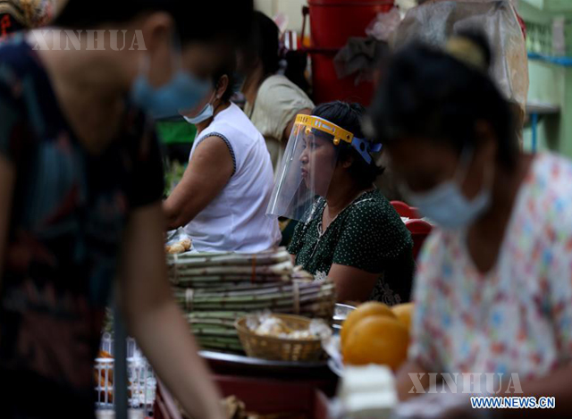 နှာခေါင်းစည်းဖြင့် ဈေးရောင်းသူများနှင့် ဈေးဝယ်သူအားတွေ့ရစဉ် (ဆင်ဟွာ)