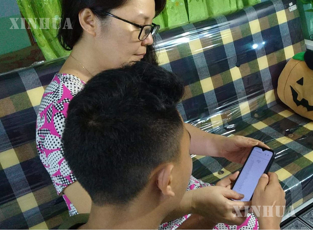 ရန်ကုန်မြို့၌ Online မှ ထုတ်ပြန်သော တက္ကသိုလ်ဝင်ခွင့် စာမေးပွဲ အောင်စာရင်းအား လက်ကိုင်ဖုန်းဖြင့် မိသားစုလိုက် ကြည့်ရှုနေမှုအား တွေ့ရစဉ် (ဆင်ဟွာ)