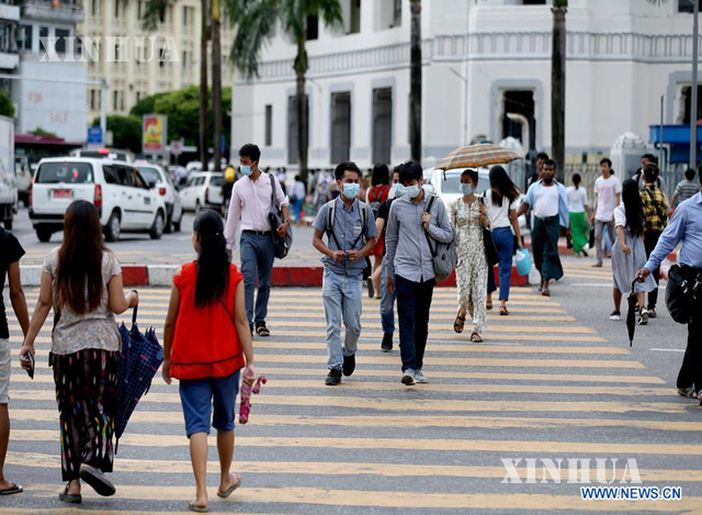 ရန်ကုန်မြို့ထဲတွင် နှာခေါင်းစည်းဖြင့် သွားလာနေကြသူများအားတွေ့ရစဉ် (ဆင်ဟွာ)