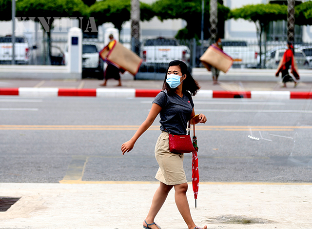 ရန်ကုန်မြို့၌ နှာခေါင်းစည်း တပ်ဆင် သွားလာသူတစ်ဦးအား တွေ့ရစဉ်(ဆင်ဟွာ)