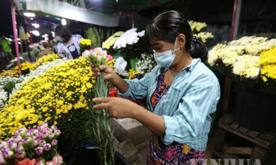 ရန်ကုန်မြို့၌ နှာခေါင်းစည်း တပ်ဆင်၍ ဈေးရောင်းနေသူ တစ်ဦးအား တွေ့ရစဉ်(ဆင်ဟွာ)