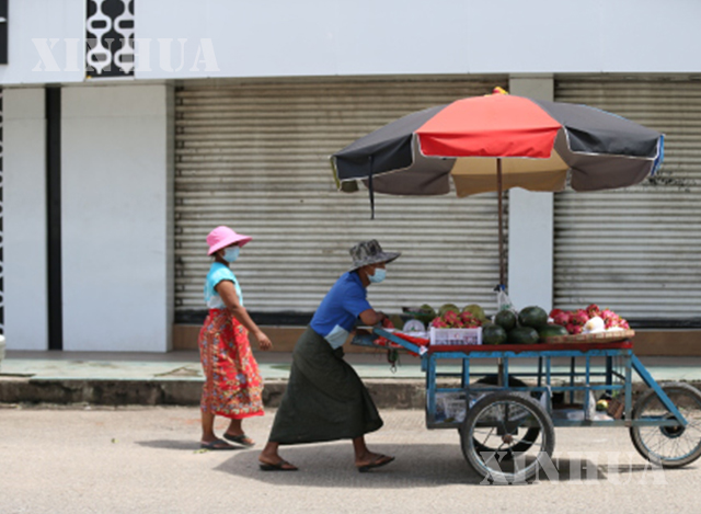 ရန်ကုန်မြို့၌ နှာခေါင်းစည်း တပ်ဆင်၍ လမ်းပေါ်တွင် ဈေးရောင်းနေသူများအား တွေ့ရစဉ်(ဆင်ဟွာ)