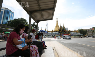 ရန်ကုန်မြို့ ရှိ ဘတ်စ်ကား မှတ်တိုင်တစ်ခု၌ ဘတ်စ်ကားစီးနင်းရန် စောင့်ဆိုင်းနေသူများအား တွေ့ရစဉ်(ဆင်ဟွာ)