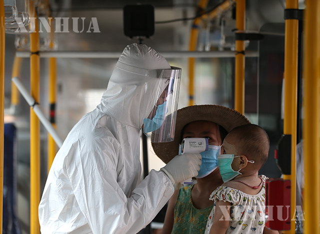 ရန်ကုန်မြို့၌ ကျန်းမာရေး ဝန်ထမ်းတစ်ဦးက ကလေးငယ်အား ကိုယ်ပူချိန်တိုင်းတာစစ်ဆေးမှု ပြုလုပ်နေသည်ကို မေလအတွင်း တွေ့ရစဉ်(ဆင်ဟွာ)