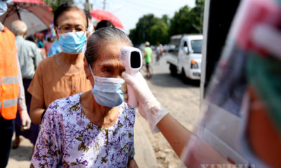 ရန်ကုန်မြို့၌ ကျန်းမာရေး ဝန်ထမ်းတစ်ဦးက ကိုယ်ပူချိန်တိုင်းတာစစ်ဆေးမှု ပြုလုပ်ပေးနေသည်ကို တွေ့ရစဉ်(ဆင်ဟွာ)