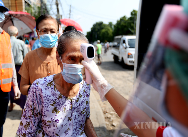 ရန်ကုန်မြို့၌ ကျန်းမာရေး ဝန်ထမ်းတစ်ဦးက ကိုယ်ပူချိန်တိုင်းတာစစ်ဆေးမှု ပြုလုပ်ပေးနေသည်ကို တွေ့ရစဉ်(ဆင်ဟွာ)
