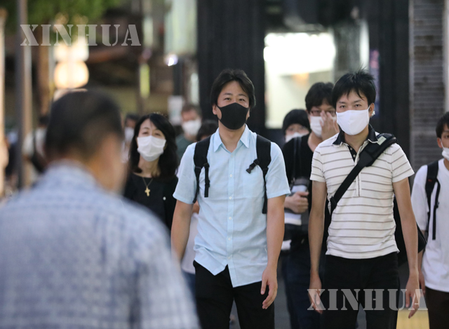 ဂျပန်နိုင်ငံ တိုကျိုမြို့ရှိ လမ်းပေါ်တွင် နှာခေါင်းစည်းတပ်ဆင်ကာ သွားလာနေသူများအား တွေ့ရစဉ် (ဆင်ဟွာ)