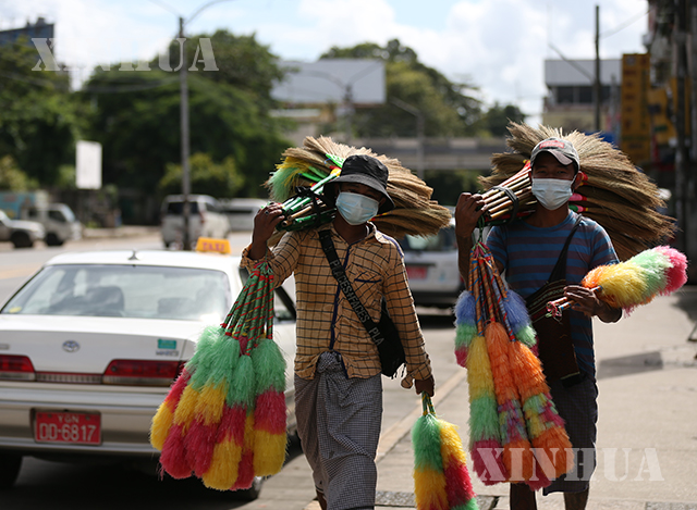 ရန်ကုန်မြို့၌ နှာခေါင်းစည်း တပ်ဆင်၍ ဈေးရောင်းသွားလာသူများအား တွေ့ရစဉ်(ဆင်ဟွာ)