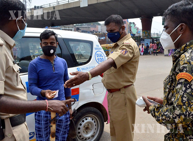 အိန္ဒိယနိုင်ငံ Bangalore မြို့တွင် COVID-19 ကပ်ရောဂါဖြစ်ပွားစဉ်အတွင်း ရဲတပ်ဖွဲ့နှင့် Bruhath Bengaluru Mahanagara Palike (BBMP) မြူနီစီပယ် အရာရှိများက နှာခေါင်းစည်း မတပ်ဆင်ထားသူတစ်ဦးအား ဒဏ်ငွေရိုက်နေစဉ် (ဓာတ်ပုံ- Str/Xinhua)