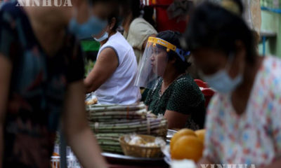 နှာခေါင်းစည်းဖြင့်ဈေးရောင်း၊ဈေးဝယ်နေသူတို့အားတွေ့ရစဉ် (ဆင်ဟွာ)