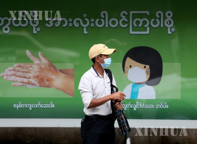 ရန်ကုန်မြို့၌ နှာခေါင်းစည်း တပ်ဆင်သွားလာသူ တစ်ဦးအား တွေ့ရစဉ်(ဆင်ဟွာ)