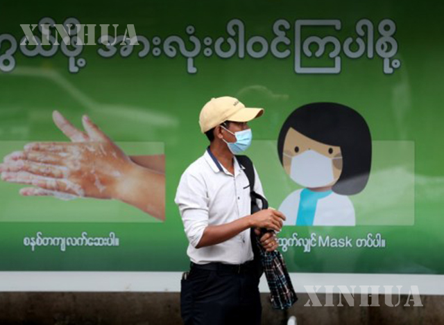 ရန်ကုန်မြို့၌ နှာခေါင်းစည်း တပ်ဆင်သွားလာသူတစ်ဦးအား တွေ့ရစဉ်(ဆင်ဟွာ)