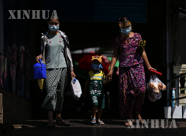 ရန်ကုန်မြို့၌ နှာခေါင်းစည်း အကာအကွယ်ဖြင့် သွားလာနေသူများအား တွေ့ရစဉ်(ဆင်ဟွာ)