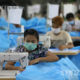 ရန်ကုန်မြို့ရှိ အထည်ချုပ်စက်ရုံတစ်ခုတွင် နှာခေါင်းစည်း တပ်ဆင်လုပ်ကိုင်နေသော အလုပ်သမားများအား တွေ့ရစဉ်(ဆင်ဟွာ)