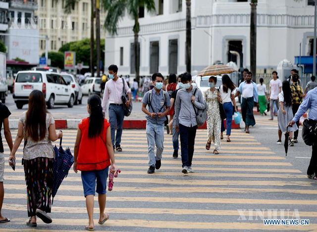 ရန်ကုန်မြို့ထဲတွင် နှာခေါင်းစည်းဖြင့် သွားလာနေသူများအားတွေ့ရစဉ် (ဆင်ဟွာ)