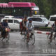 ရန်ကုန်မြို့တွင် မိုးသည်းထန်စွာရွာသွန်းပြီးနောက် စက်ဘီးဖြင့်သွားလာနေကြသူများအားတွေ့ရစဉ် (ဆင်ဟွာ)