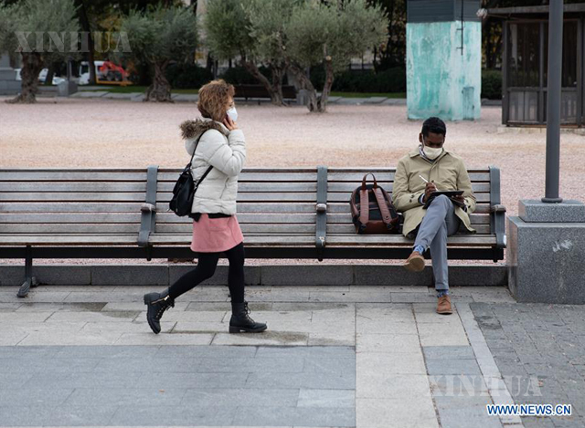 စပိန်နိုင်ငံ မက်ဒရစ်မြို့ရှိ ကိုလံဘတ်ပလာဇာတွင် နှာခေါင်းတပ်ဆင်ထားသူများကို တွေ့ရစဉ် (ဆင်ဟွာ)