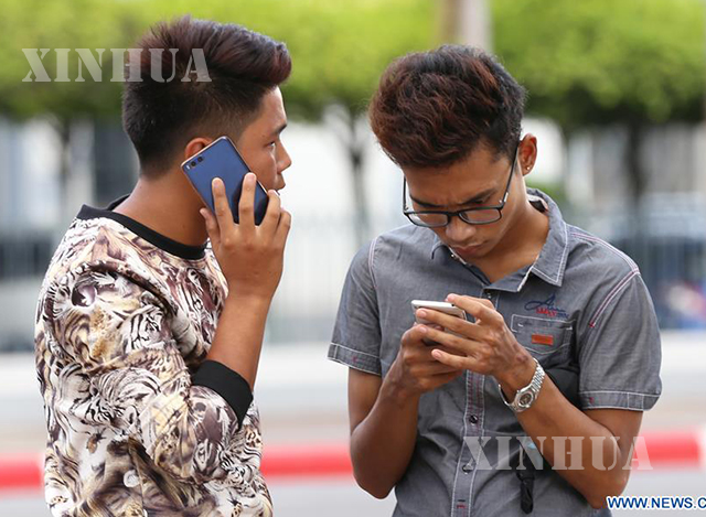 ရန်ကုန်မြို့၌ တယ်လီဖုန်း ဆက်သွယ်ပြောဆိုနေသူ နှစ်ဦးအား တွေ့ရစဉ်(ဆင်ဟွာ)