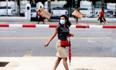 ရန်ကုန်မြို့ မဟာဗန္ဓုလပန်းခြံအတွင်း နှာခေါင်းစည်း တပ်ဆင်၍ ဈေးရောင်းနေသူ တစ်ဦးအား တွေ့ရစဉ်(ဆင်ဟွာ)