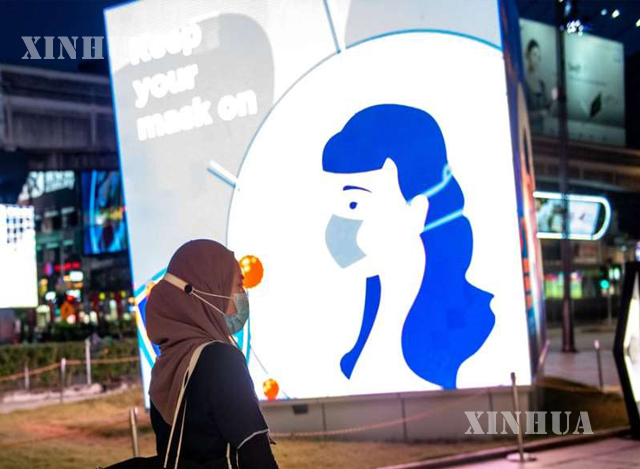 မလေးရှားနိုင်ငံ ကွာလာလမ်ပူမြို့ရှိ လမ်းပေါ်တွင် နှာခေါင်းစည်းတပ်ဆင်ထားသော အမျိုးသမီးတစ်ဦးကို တွေ့ရစဉ် (ဆင်ဟွာ)
