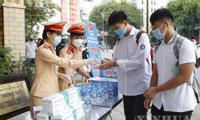 ဗီယက်နမ်နိုင်ငံ ဟနွိုင်းမြို့တွင် ဩဂုတ်၉ ရက်က အထက်တန်းကျောင်းစာမွေးပွဲသွားရောက်ဖြေဆိုမည့် ကျောင်းသားကျောင်းသူများကို ယာဉ်ထိန်းရဲများက ရေသန့်ဗူး ဝေငှပေးနေစဉ်(ဆင်ဟွာ)
