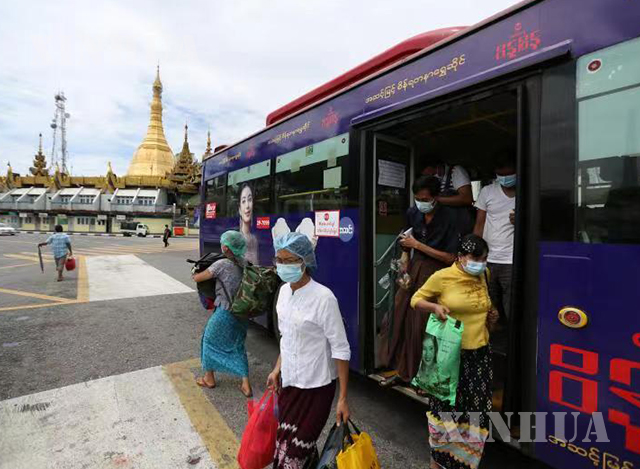 ရန်ကုန်မြို့၌ နှာခေါင်းစည်း တပ်ဆင်၍ သွားလာသူများအား တွေ့ရစဉ်(ဆင်ဟွာ)