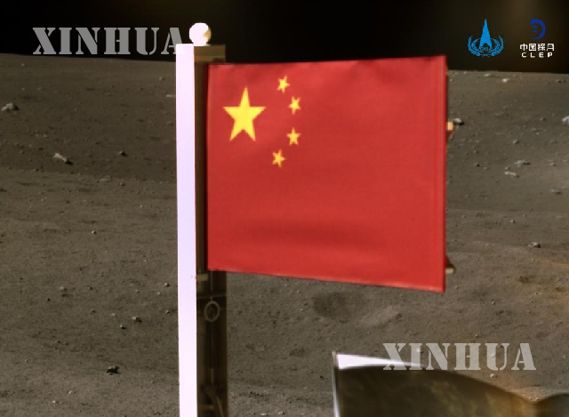 တရုတ် အမျိုးသား အာကာသစီမံခန့်ခွဲမှုဦးစီးဌာန (CNSA) က ဒီဇင်ဘာ ၄ ရက်တွင် ထုတ်ပြန်လိုက်သော လမျက်နှာပြင်ပေါ်တွင် မြင်တွေ့ရသည့် Chang'e-5 အာကာသယာဉ်မှ လွှင့်ထူထားသော တရုတ်နိုင်ငံအလံ ဓာတ်ပုံကို တွေ့ရစဉ် (ဆင်ဟွာ)