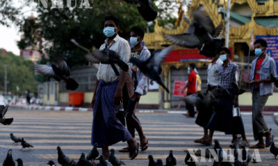 ရန်ကုန်မြို့တွင် နှာခေါင်းစည်း တပ်ဆင်၍ သွားလာနေသူများအား တွေ့ရစဉ်(ဆင်ဟွာ)