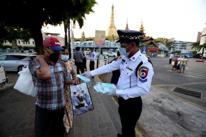 ရန်ကုန်မြို့တွင် သွားလာနေသူများအား နှာခေါင်းစည်းများ ဝေငှပေးနေသည်ကို တွေ့ရစဉ်(ဆင်ဟွာ)