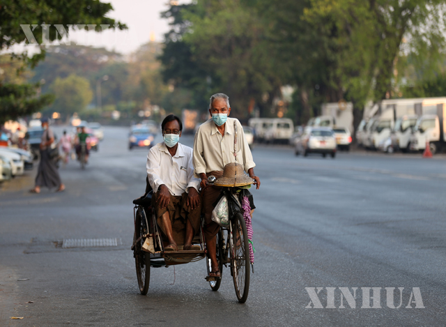 ရန်ကုန်မြို့တွင် နှာခေါင်းစည်း တပ်ဆင်သွားလာသူများအား တွေ့ရစဉ်(ဆင်ဟွာ)