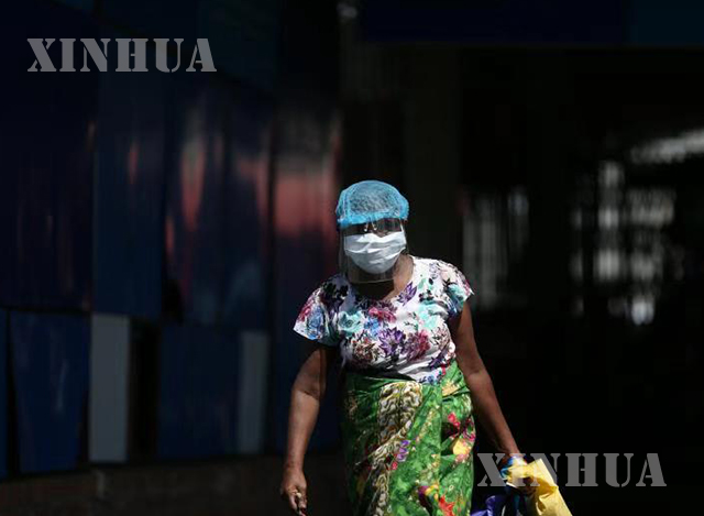 ရန်ကုန်မြို့၌ နှာခေါင်းစည်း ၊ အကာအကွယ်များ တပ်ဆင်သွားလာသူ တစ်ဦးအား တွေ့ရစဉ်(ဆင်ဟွာ)