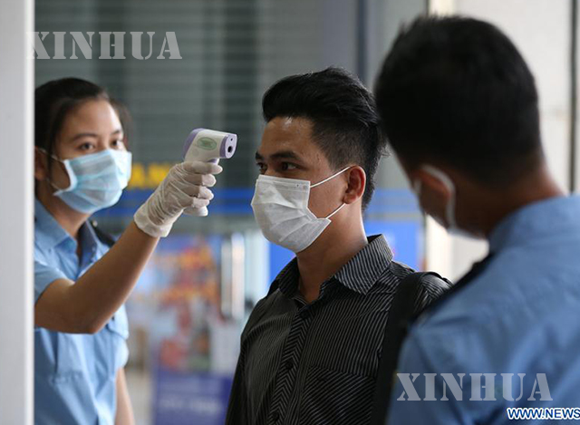ရန်ကုန်မြို့၌ နှာခေါင်းစည်း တပ်ဆင်ထားသော အမျိုးသား တစ်ဦးအား ကိုယ်ပူချိန် တိုင်းတာစစ်ဆေးမှု ပြုလုပ်နေသည်ကို တွေ့ရစဉ်(ဆင်ဟွာ)