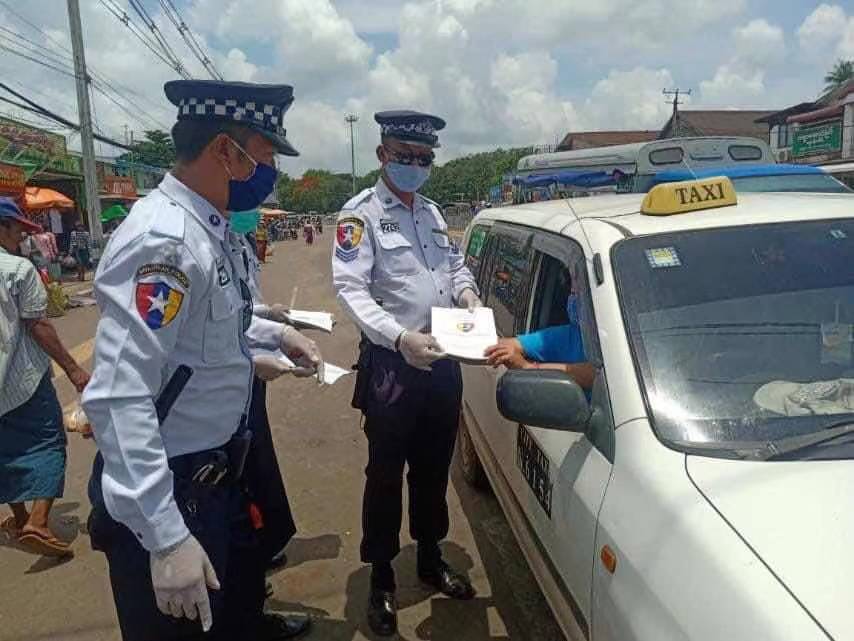 ယာဉ်အန္တရာယ်ကင်းရှင်းရေးနှင့် မော်တော်ယာဉ်စီမံခန့်ခွဲမှု ဥပဒေအား ယာဉ်မောင်းများထံသို့ ယာဉ်ထိန်းရဲတပ်ဖွဲ့ဝင်များက ဖြန့်ဝေပေးနေစဉ် (Yangon Traffic Police)