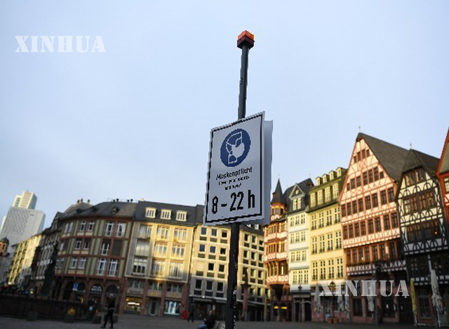 ဂျာမနီနိုင်ငံ Frankfurt မြို့ Römerberg ရင်ပြင် ရှိ လူများနှာခေါင်းစည်းဝတ်ဆင်ရန် သတိပေးသည့်ဆိုင်းဘုတ်အား ဇန်နဝါရီ ၂၀ ရက်၌ တွေ့ရစဉ်(ဆင်ဟွာ)