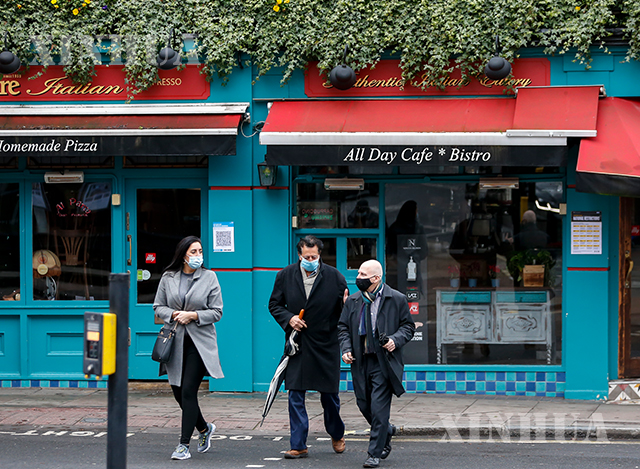 ဗြိတိန်နိုင်ငံတွင် ပိတ်သိမ်းထားသည့် စားသောက်ဆိုင်ရှေ့တစ်ခု၌ လူများ နှာခေါင်းစည်းတပ်၍ ဖြတ်လျှောက်သွားသည်ကို ဇန်နဝါရီ ၁၉ ရက်က မြင်တွေ့ရစဉ်(ဆင်ဟွာ)