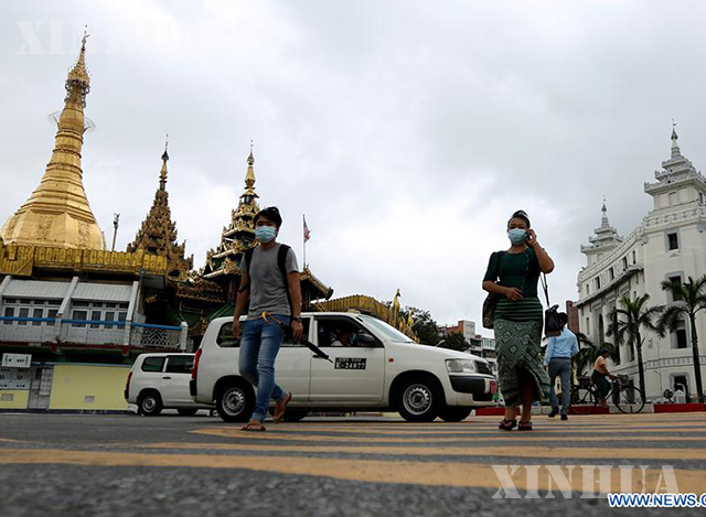 ရန်ကုန်မြို့၌ နှာခေါင်းစည်း တပ်ဆင်သွားလာသူများအား တွေ့ရစဉ်(ဆင်ဟွာ)