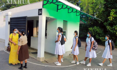 သီရိလင်္ကာနိုင်ငံ ကိုလံဘိုမြို့ရှိ မိန်းကလေးကျောင်း၏ ဝင်ပေါက်တွင် ဆရာမတစ်ဦး ကိုယ်အပူချိန်တိုင်းနေသည်ကို ဇန်နဝါရီ ၂၅ ရက်က တွေ့ရစဉ် (ဆင်ဟွာ)