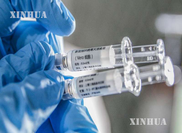 တရုတ်နိုင်ငံ ပေကျင်းမြို့ရှိ Sinovac Biotech လီမိတက်တွင် COVID-19 ကာကွယ်ဆေး (inactivated vaccine) နမူနာများကို ဝန်ထမ်းတစ်ဦးက ပြသနေစဉ် (ဆင်ဟွာ)