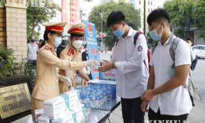 ဗီယက်နမ်နိုင်ငံ ဟနွိုင်းမြို့တွင် အထက်တန်းစာမေးပွဲသွားရောက်ဖြေဆိုကြမည့် ကျောင်းသူကျောင်းသားများအား ယာဉ်ထိန်းရဲများက သောက်ရေးပုလင်းများ ဝေငှပေးနေစဉ်(ဆင်ဟွာ)