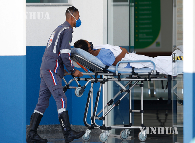 ဘရာဇီးနိုင်ငံ Goiás ပြည်နယ်တွင် ဖေဖော်ဝါရီ ၂၅ ရက်၌ ဆေးဘက်ဆိုင်ရာဝန်ထမ်းက COVID-19 ရောဂါကူးစက်ခံထားရသူအား ဆေးရုံအတွင်းသို့ ပို့ဆောင်ပေးနေစဉ်(ဆင်ဟွာ)