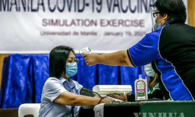 ဖိလစ်ပိုင်နိုင်ငံ မနီလာမြို့ COVID-19 ကာကွယ်ဆေးထိုးလေ့ကျင့်မှုအတွင်း နှာခေါင်းစည်းတပ်ဆင်ထားသော အမျိုးသမီးတစ်ဦးကို ခန္ဓာကိုယ်အပူချိန် တိုင်းတာနေသည်ကို တွေ့ရစဉ် (ဆင်ဟွာ)