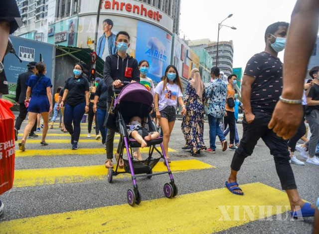 မလေးရှားနိုင်ငံ ကွာလာလမ်ပူမြို့ရှိ လမ်းမတစ်နေရာတွင် နှာခေါင်းစည်းတပ်ဆင်ထားသူများ သွားလာနေသည်ကို တွေ့ရစဉ် (ဆင်ဟွာ)