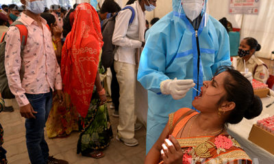 အိန္ဒိယနိုင်ငံ နယူးဒေလီမြို့၌ ကျန်းမာရေးဝန်ထမ်း တစ်ဦးက COVID-19 ရောဂါ စစ်ဆေးရန် Swab ရယူနေစဉ်(ဆင်ဟွာ)