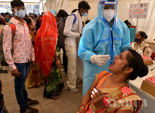 အိန္ဒိယနိုင်ငံ နယူးဒေလီမြို့၌ ကျန်းမာရေးဝန်ထမ်း တစ်ဦးက COVID-19 ရောဂါ စစ်ဆေးရန် Swab ရယူနေစဉ်(ဆင်ဟွာ)